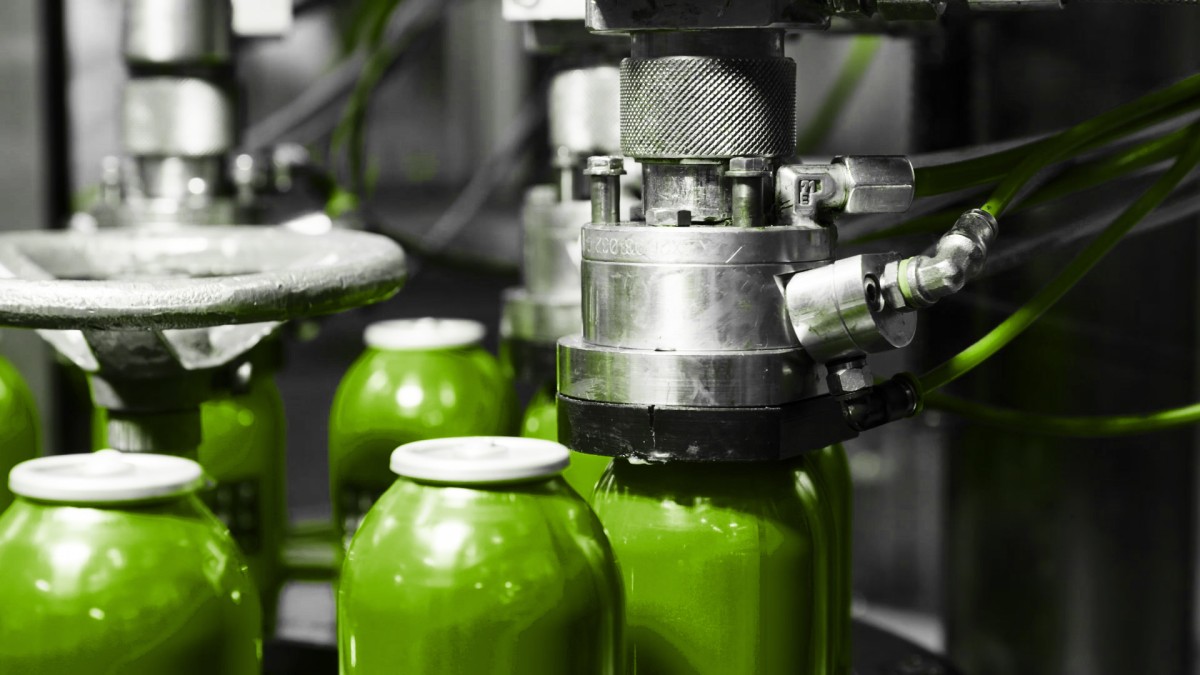 Grüne Bag-On-Valve Dosen während des Füllprozesses Grüne Bag-On-Valve Dosen während des Füllprozesses